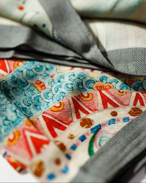 Close-up of colorful fabric with patterns and a gray fabric swatch.